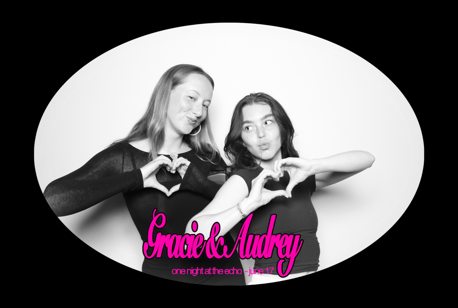 Two female guests posing for a photo making hearts with their hands