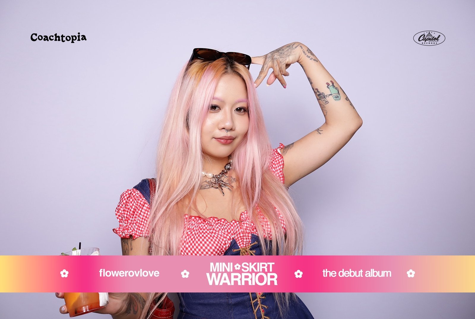 Guest posing against a lilac backdrop in a branded photo booth at a Capitol Records event in Los Angeles